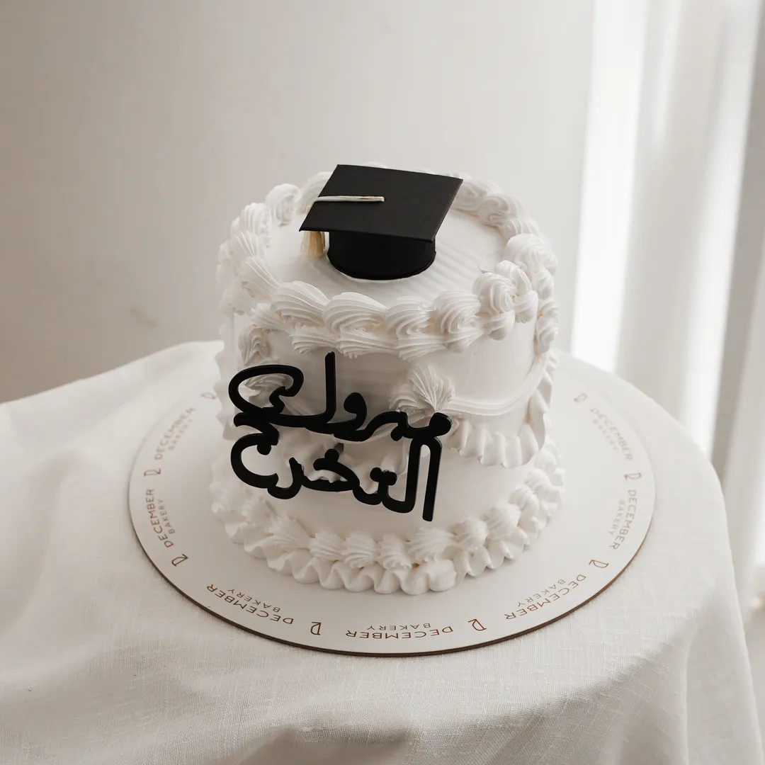 كيكه التخرج البيضاء الكريميه وقبعه التخرج